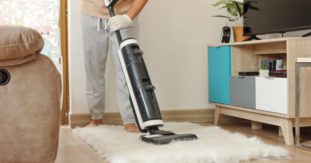 14 Best Carpet Deodorizer Powders: Expert-Recommended for Pet Odors 25 man vacuuming carpet in the living room