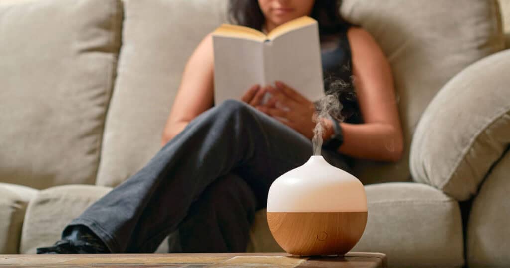 Are Essential Oils Safe for Your Lungs? VOCs and GC/MS Tested Brands 15 lady reading book with diffuser in the table