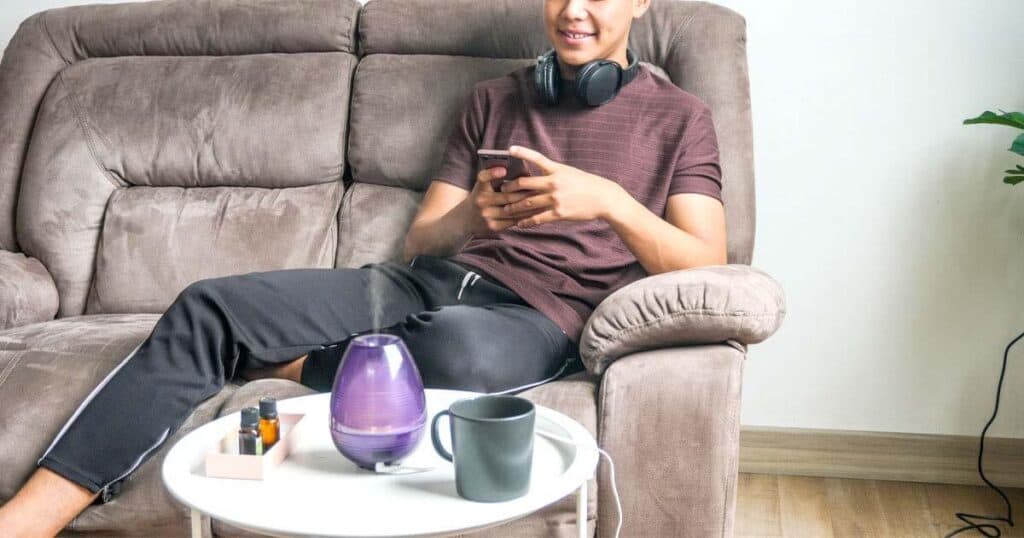 Are Essential Oils Safe for Your Lungs? VOCs and GC/MS Tested Brands 24 teenager using phone and essential oil diffuser