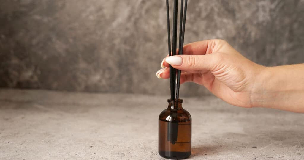 lady removing reed diffuser sticks
