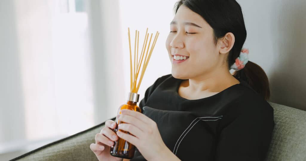lady smelling reed diffuser