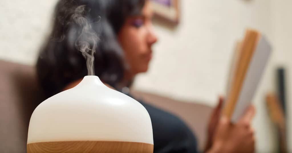 The 10 Healthiest Ways to Fragrance Your Home: A 2026 Guide 40 woman reading book while using aroma diffuser